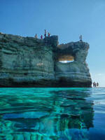 Blue water in Cyprus - sea caves and other geological formations seen from a boat along the Cyprus coastline.